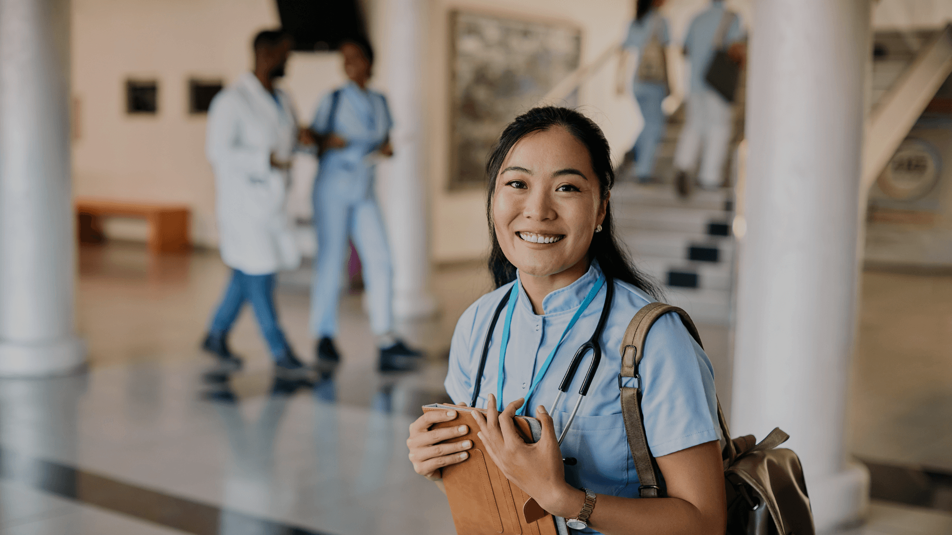 Vrouwelijke zorgmedewerker met rugzak en ipad op school